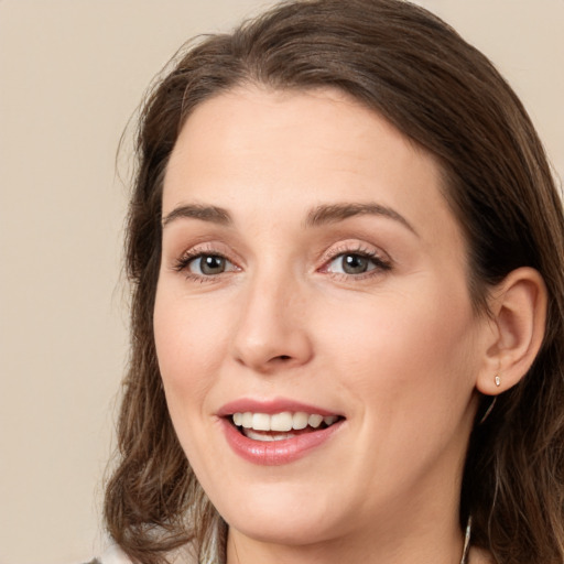 Joyful white young-adult female with long  brown hair and brown eyes