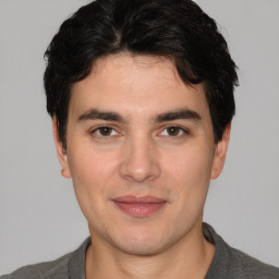 Joyful white young-adult male with short  black hair and brown eyes