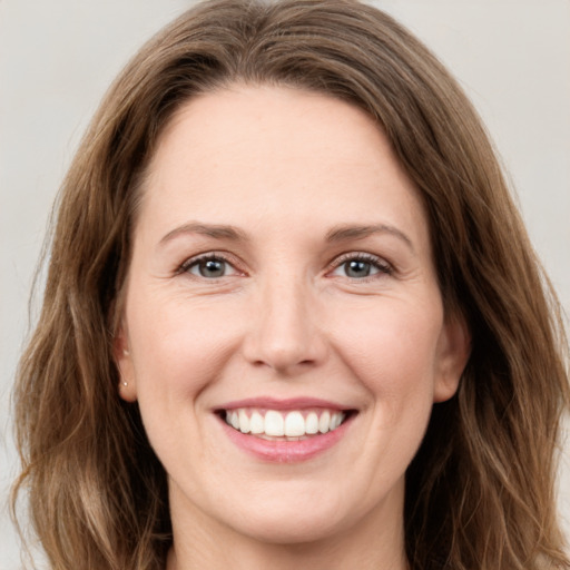 Joyful white young-adult female with long  brown hair and green eyes