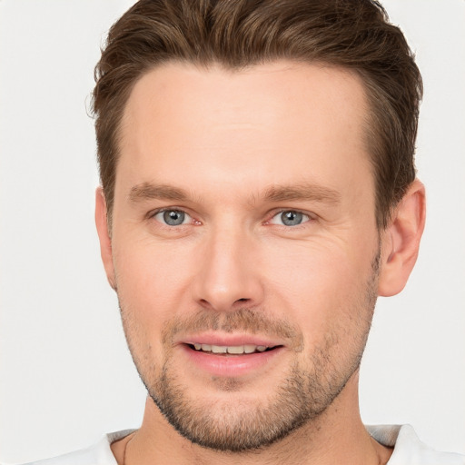 Joyful white young-adult male with short  brown hair and grey eyes