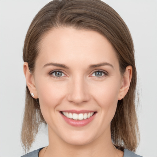 Joyful white young-adult female with medium  brown hair and grey eyes