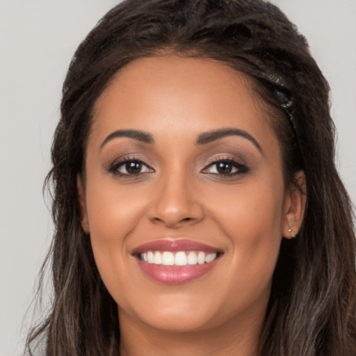 Joyful latino young-adult female with long  brown hair and brown eyes