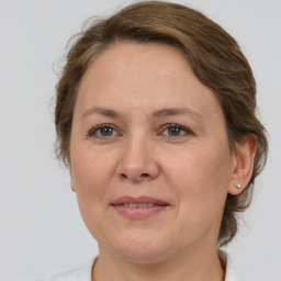 Joyful white adult female with medium  brown hair and grey eyes