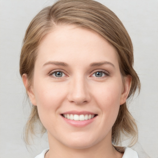 Joyful white young-adult female with medium  brown hair and blue eyes