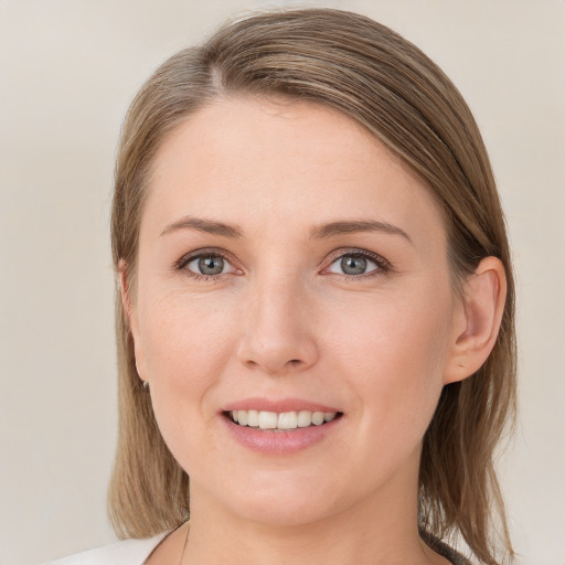 Joyful white young-adult female with medium  brown hair and grey eyes