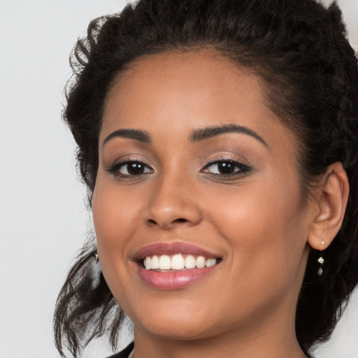 Joyful latino young-adult female with long  brown hair and brown eyes