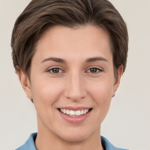 Joyful white young-adult female with short  brown hair and grey eyes