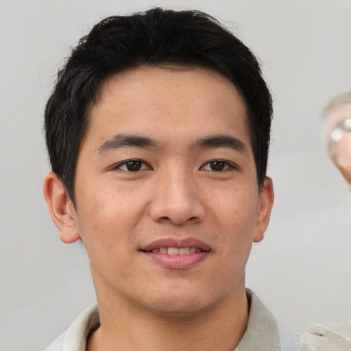 Joyful asian young-adult male with short  brown hair and brown eyes