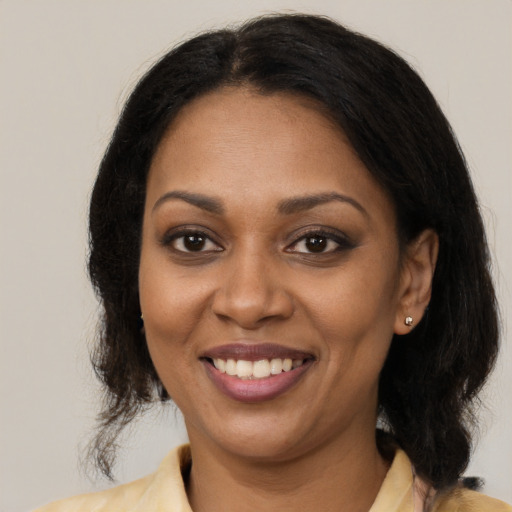 Joyful black young-adult female with medium  brown hair and brown eyes