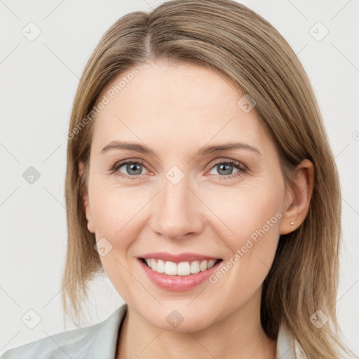 Joyful white young-adult female with medium  brown hair and grey eyes