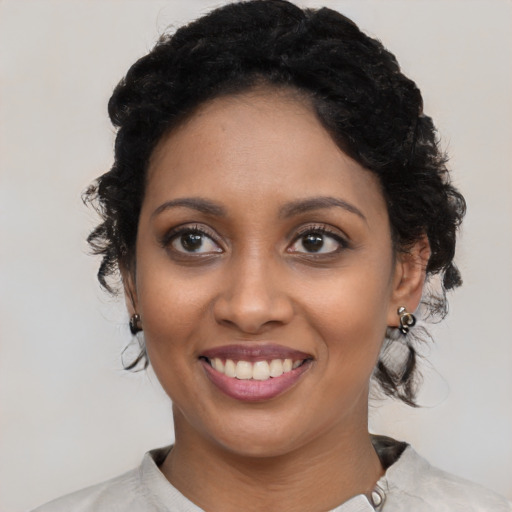 Joyful black young-adult female with medium  black hair and brown eyes