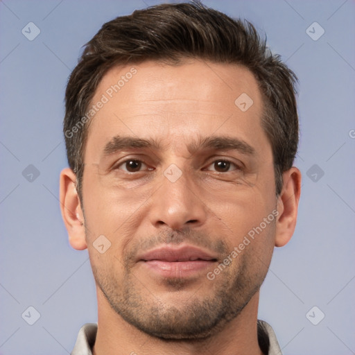 Joyful white adult male with short  brown hair and brown eyes