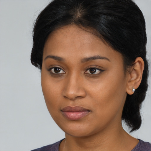 Joyful black young-adult female with medium  brown hair and brown eyes
