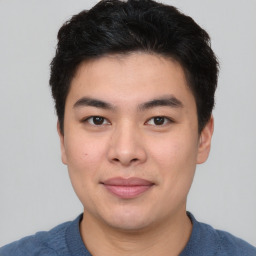 Joyful asian young-adult male with short  black hair and brown eyes