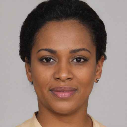 Joyful black young-adult female with short  black hair and brown eyes