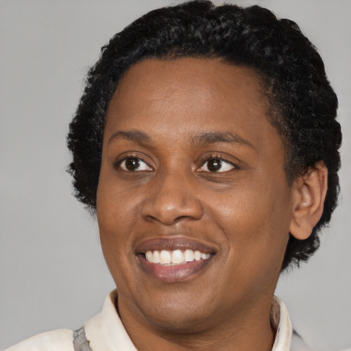 Joyful black young-adult female with short  black hair and brown eyes