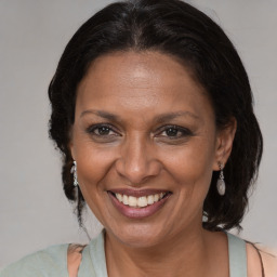 Joyful black adult female with medium  brown hair and brown eyes