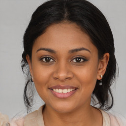 Joyful latino young-adult female with medium  brown hair and brown eyes