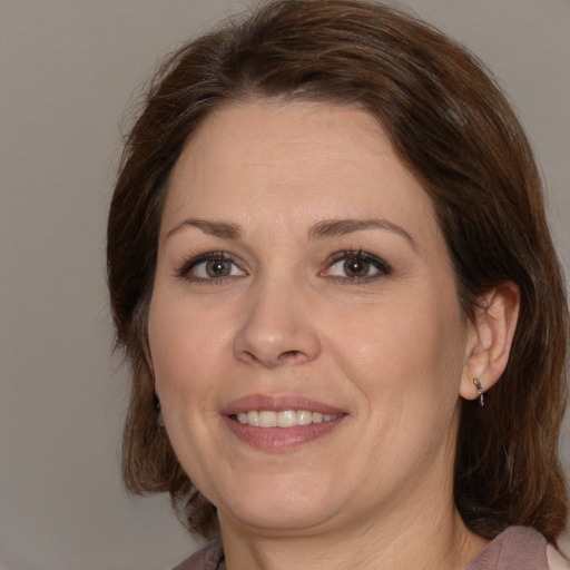 Joyful white adult female with medium  brown hair and brown eyes