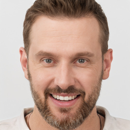 Joyful white young-adult male with short  brown hair and grey eyes