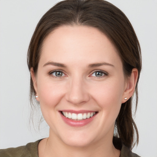 Joyful white young-adult female with medium  brown hair and grey eyes