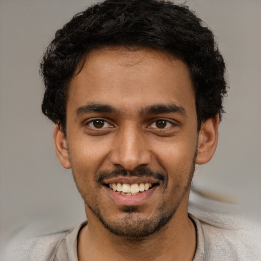 Joyful white young-adult male with short  black hair and brown eyes
