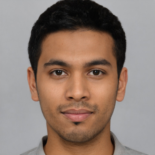 Joyful latino young-adult male with short  black hair and brown eyes