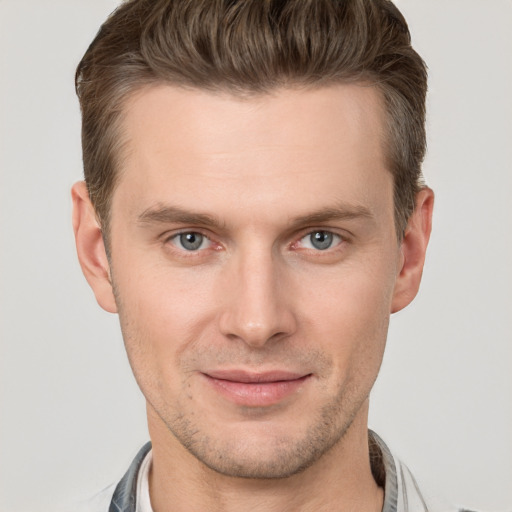 Joyful white young-adult male with short  brown hair and grey eyes