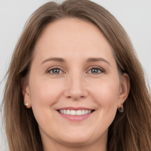 Joyful white young-adult female with long  brown hair and grey eyes