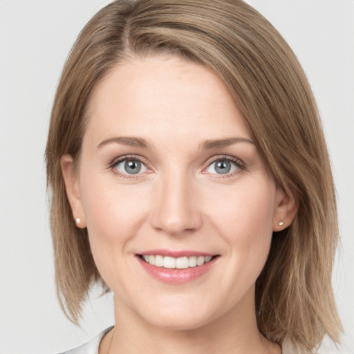 Joyful white young-adult female with medium  brown hair and grey eyes