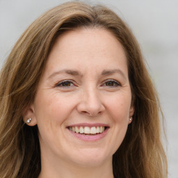 Joyful white adult female with long  brown hair and brown eyes