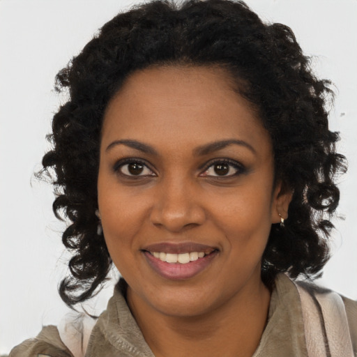 Joyful black young-adult female with long  brown hair and brown eyes