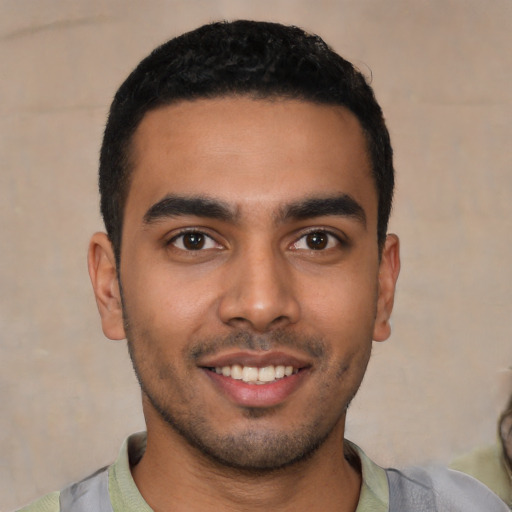 Joyful latino young-adult male with short  black hair and brown eyes