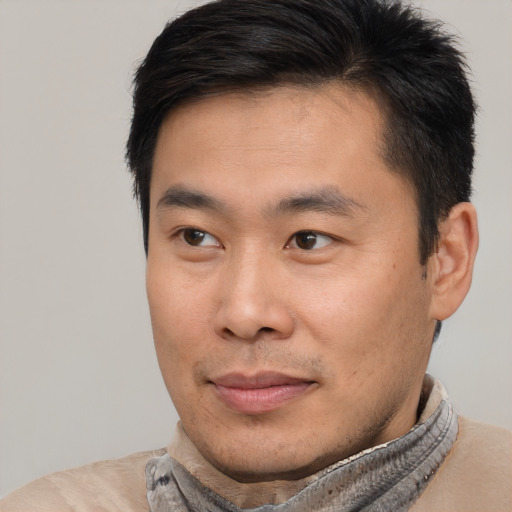 Joyful asian young-adult male with short  brown hair and brown eyes