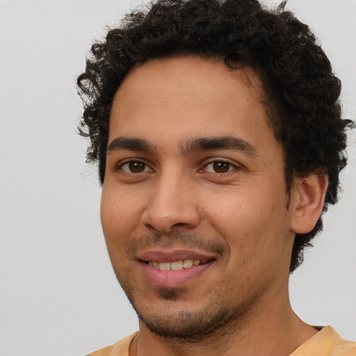 Joyful latino young-adult male with short  brown hair and brown eyes