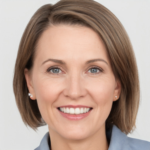 Joyful white adult female with medium  brown hair and grey eyes