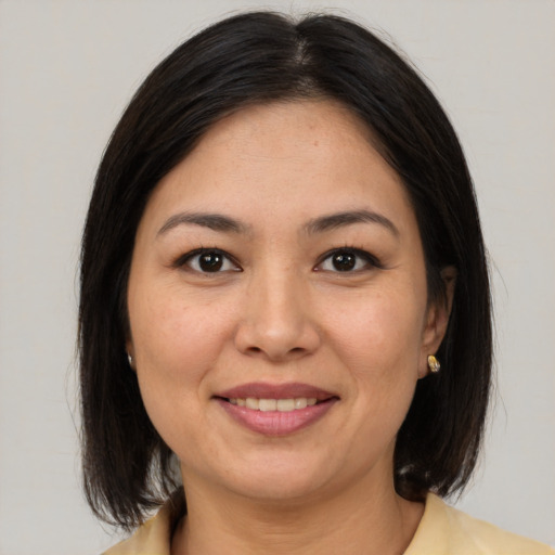 Joyful latino young-adult female with medium  brown hair and brown eyes