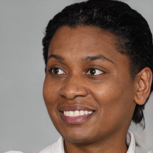 Joyful black young-adult female with short  black hair and brown eyes