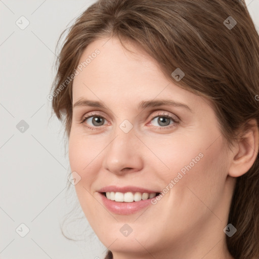 Joyful white young-adult female with medium  brown hair and grey eyes