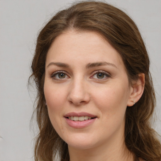 Joyful white young-adult female with long  brown hair and green eyes