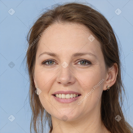 Joyful white adult female with long  brown hair and grey eyes