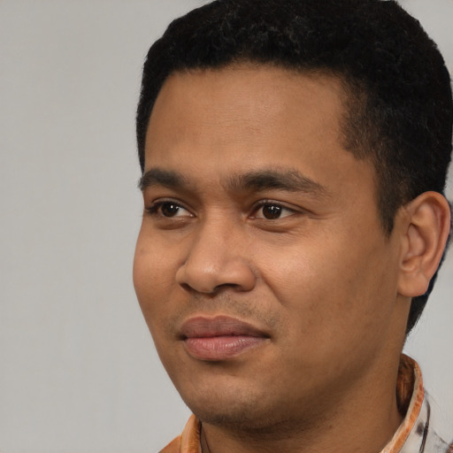 Joyful latino young-adult male with short  black hair and brown eyes