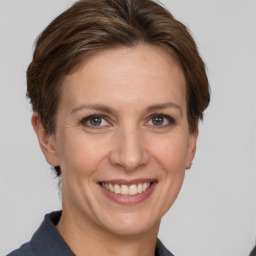 Joyful white adult female with medium  brown hair and grey eyes