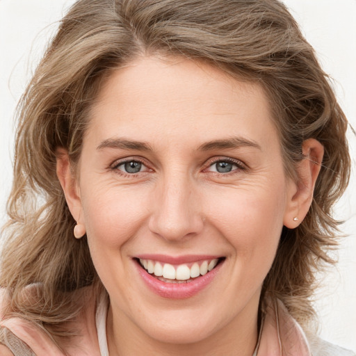 Joyful white young-adult female with long  brown hair and blue eyes