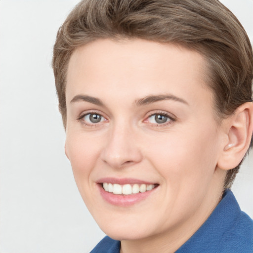 Joyful white young-adult female with short  brown hair and blue eyes