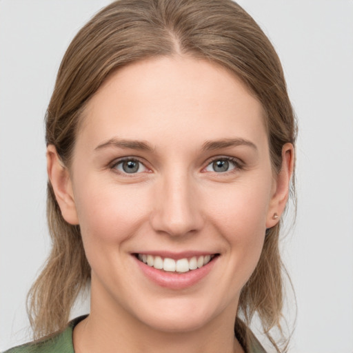 Joyful white young-adult female with medium  brown hair and grey eyes