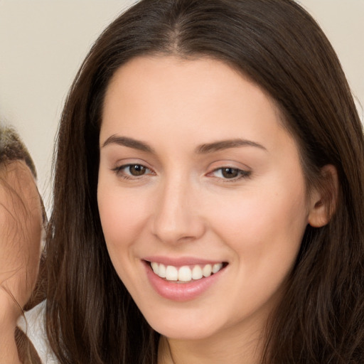 Joyful white young-adult female with long  brown hair and brown eyes