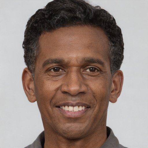 Joyful latino adult male with short  black hair and brown eyes