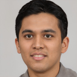 Joyful latino young-adult male with short  black hair and brown eyes