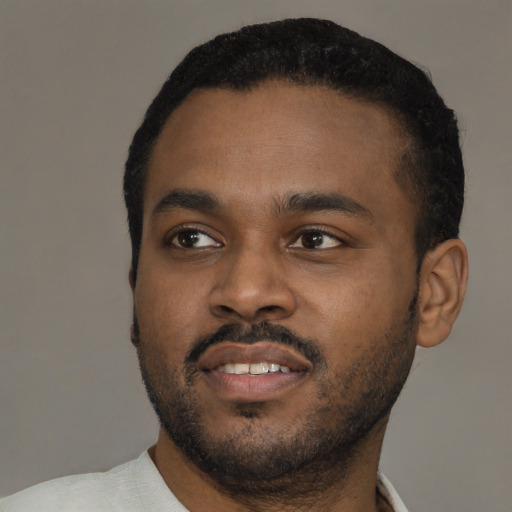 Joyful black young-adult male with short  black hair and brown eyes